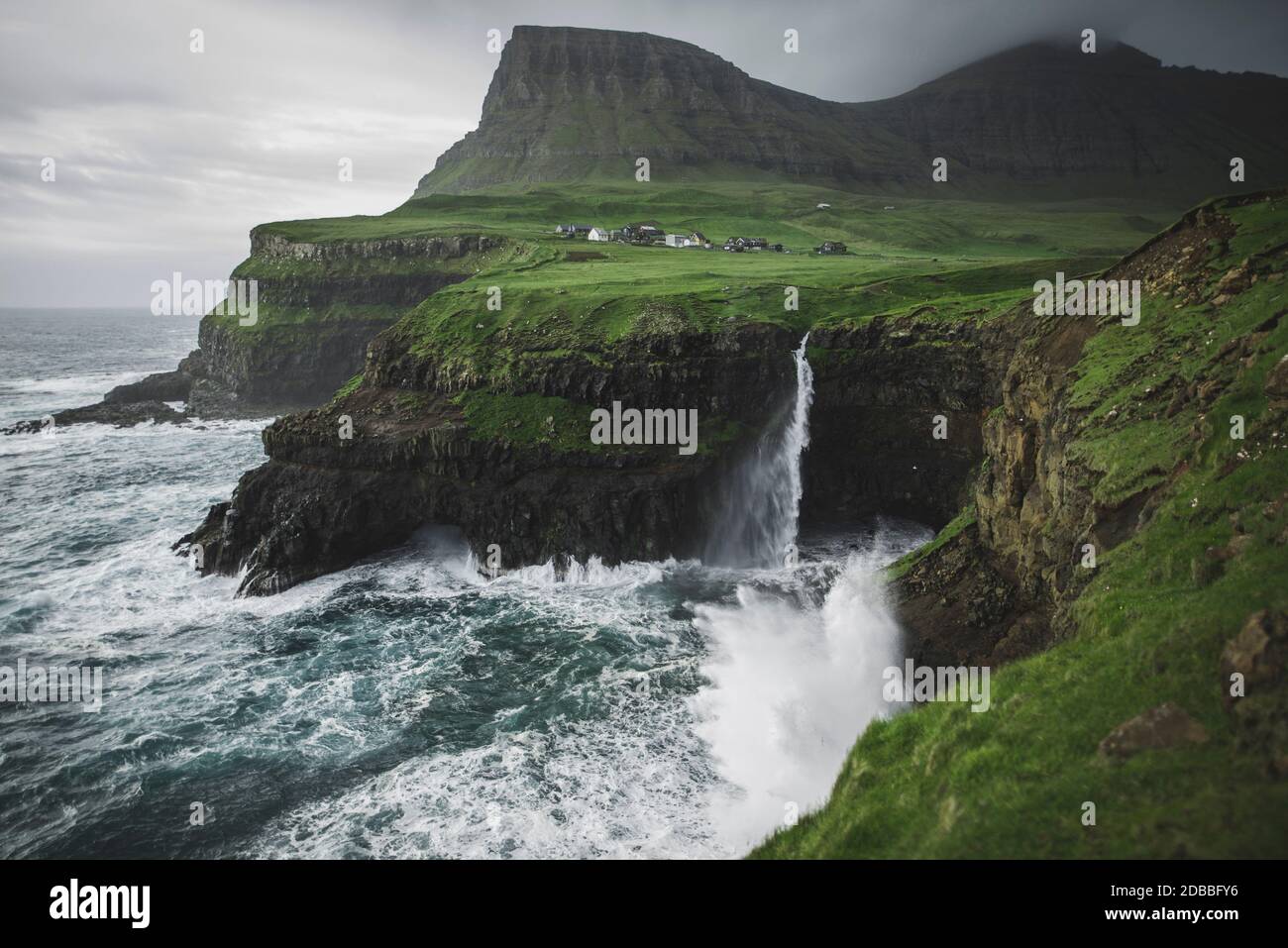 Denmark, Faroe Islands, Gasadalur village, Mulafossur Waterfall, Mulafossur Waterfall falling from cliff into ocean Stock Photo