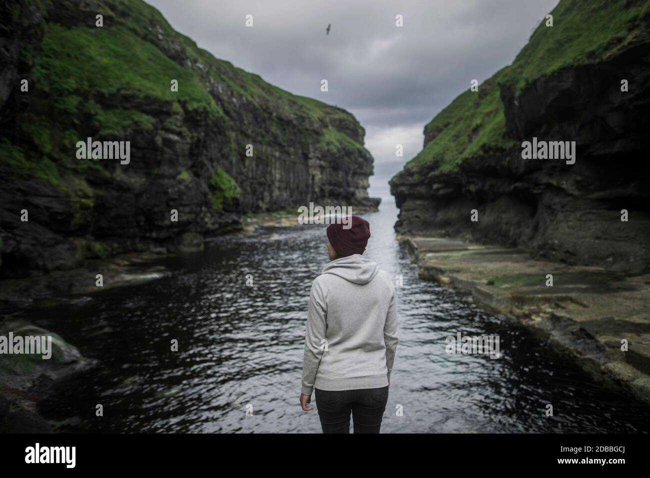 Denmark, Faroe Islands, Gjgv, Woman standing in gorge Stock Photo
