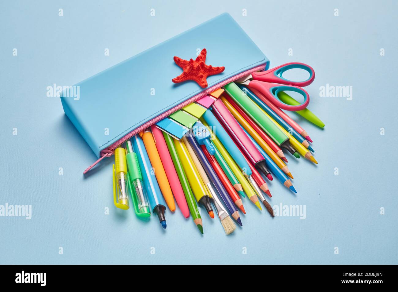 Blue pencil case with a red star on a light blue background. School objects for students Stock