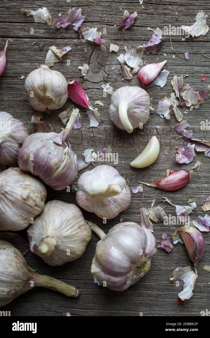 The process of cleaning garlic. Garlic and leaves on wooden background