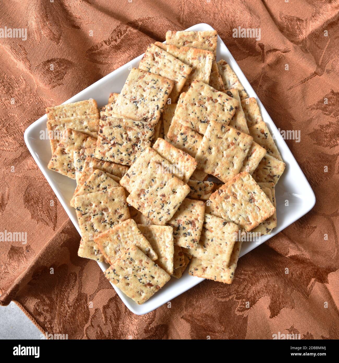 A dish of whole grain crackers loaded with garlic, onion, poppy and