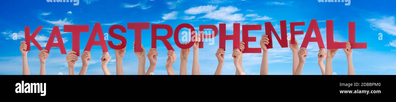 People Hands Holding Colorful German Word Katastrophenfall Means Emergency. Blue Sky As Background Stock Photo