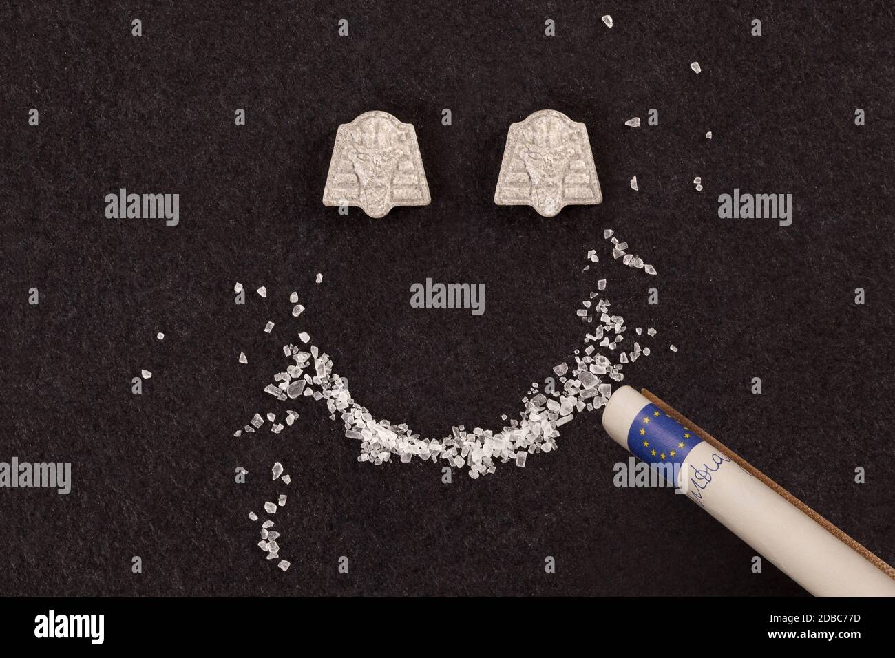 MDMA crystal and ecstasy pills forming smiley face. Snorting, party drugs abuse and addiction.. Stock Photo