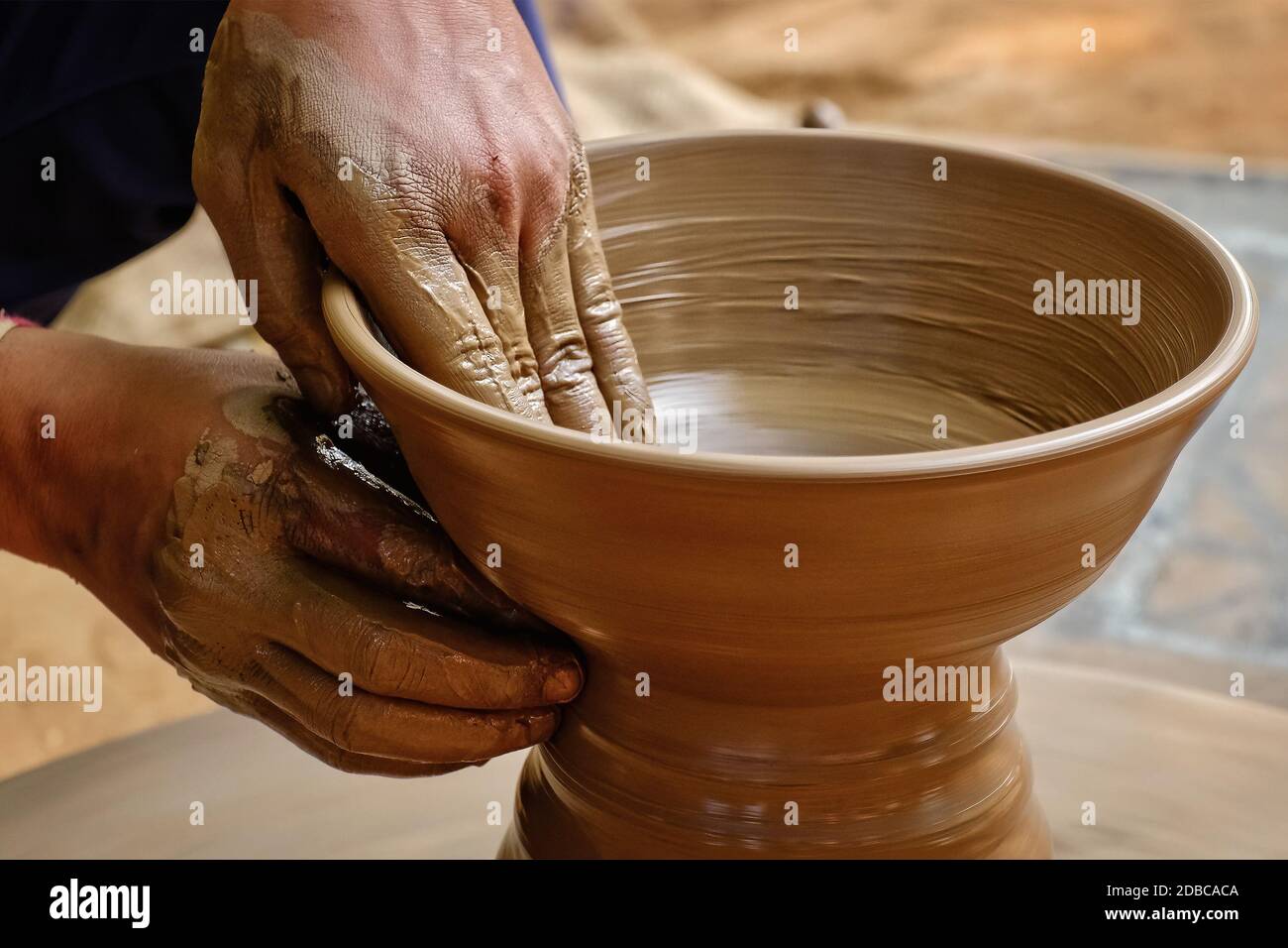 Pottery skilled wet hands of potter shaping the clay on potter wheel