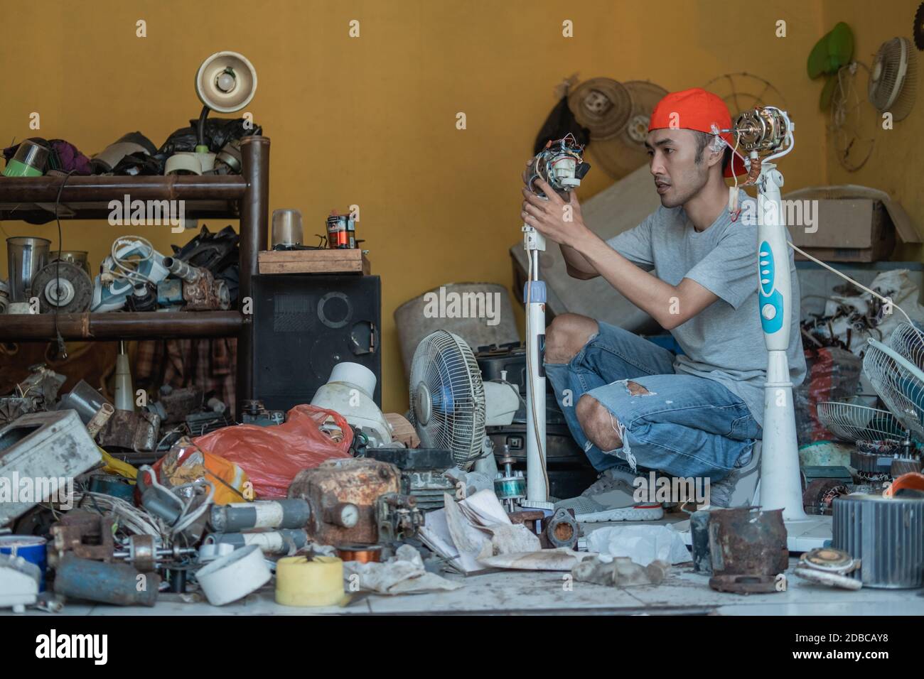 electronics repairman fixing a broken fan at an electronics repair shop Stock Photo