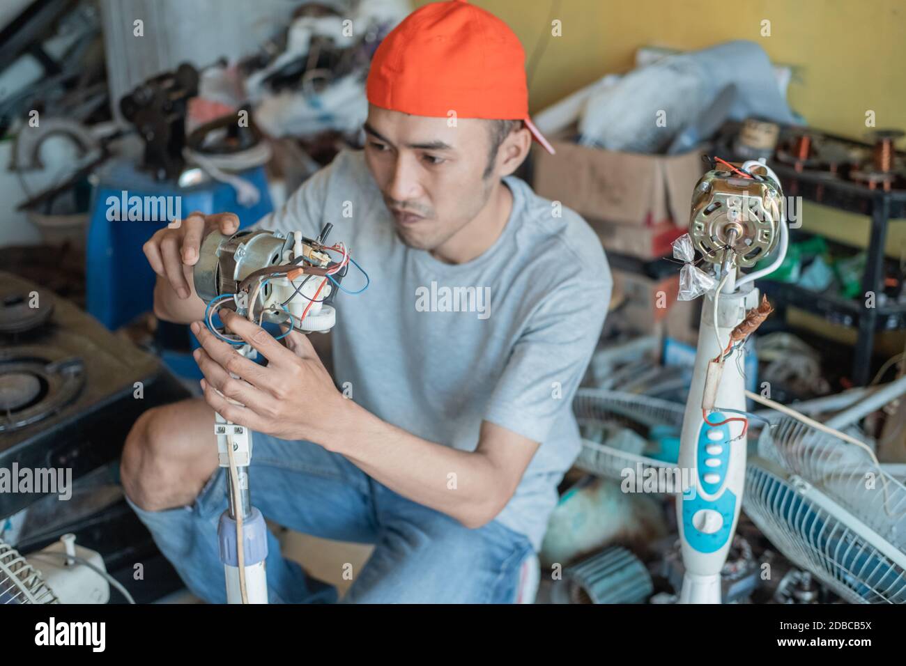 electronics repairman fixes a broken fan dynamo at an electronics repair shop Stock Photo