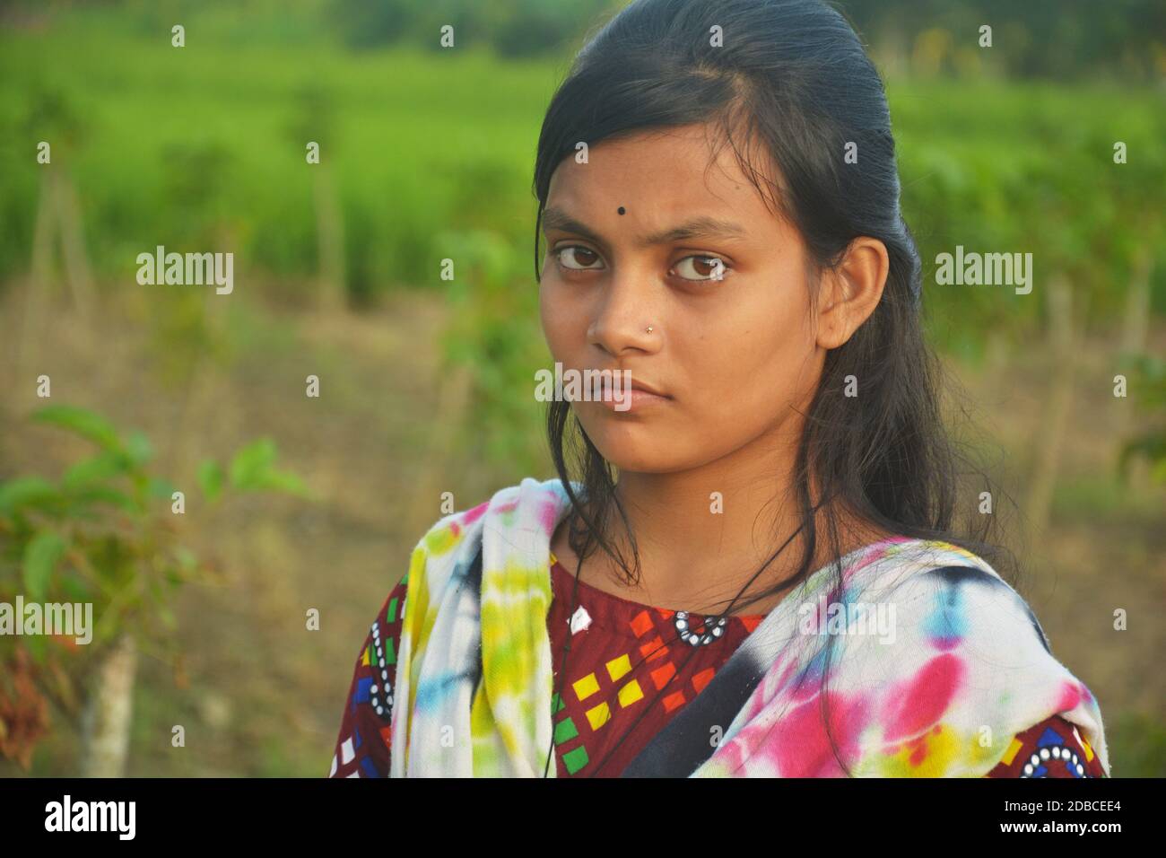 Close up of a teenage Indian Bengali girl wearing colored salwar kameez with long dark hairs, selective focusing Stock Photo