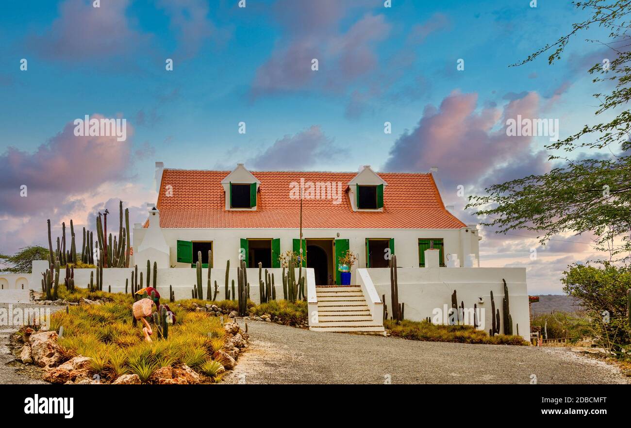 A white plaster house in Curacao with a red tile roof Stock Photo - Alamy