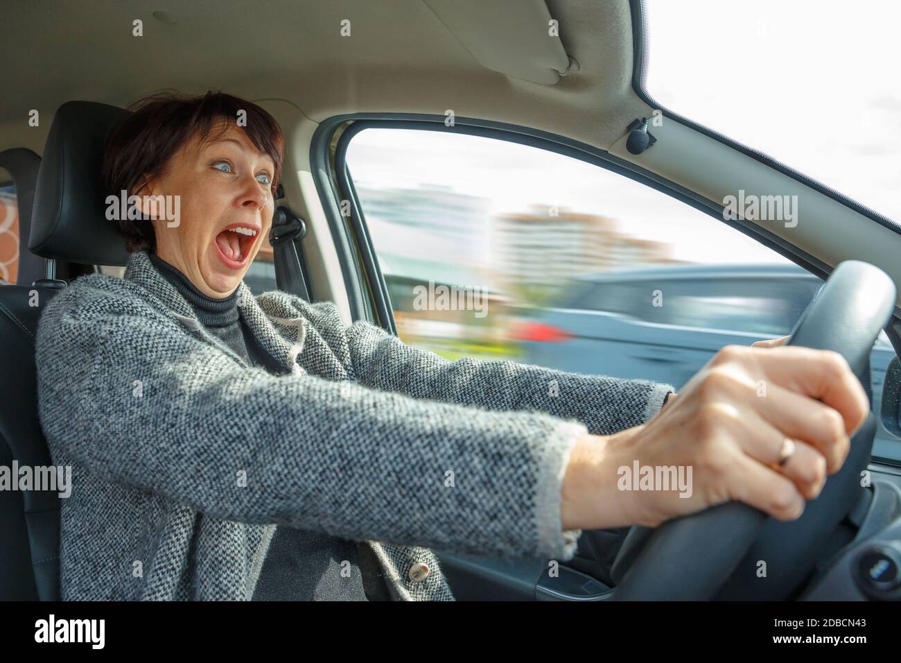 Portrait of a woman driving a car. Stress when learning to drive Stock Photo