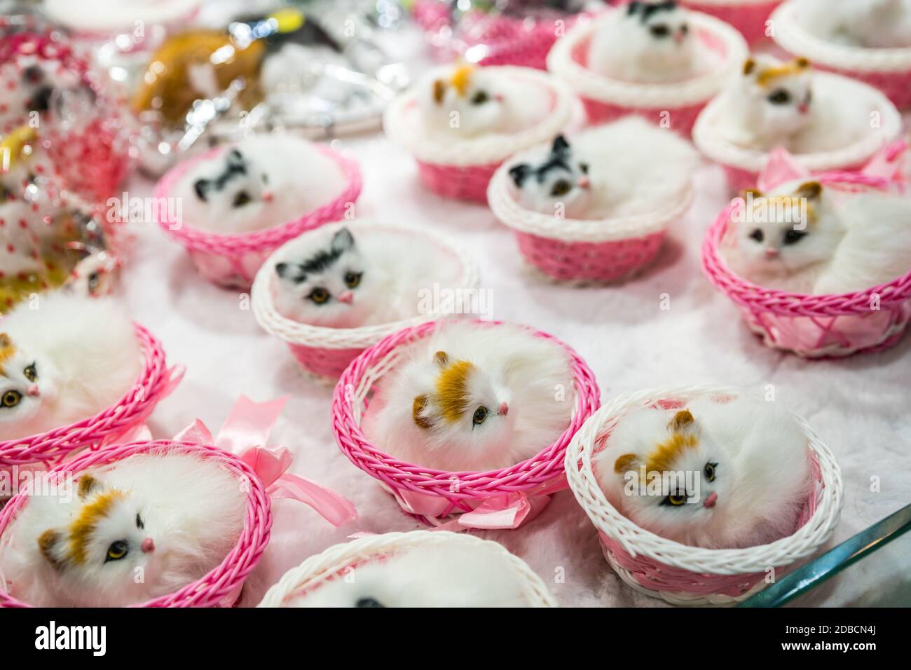 A soft focus of decorative figurine cats in a basket displayed in a shop in Ci Qi Kou Old Town,  Chongqing, China Stock Photo