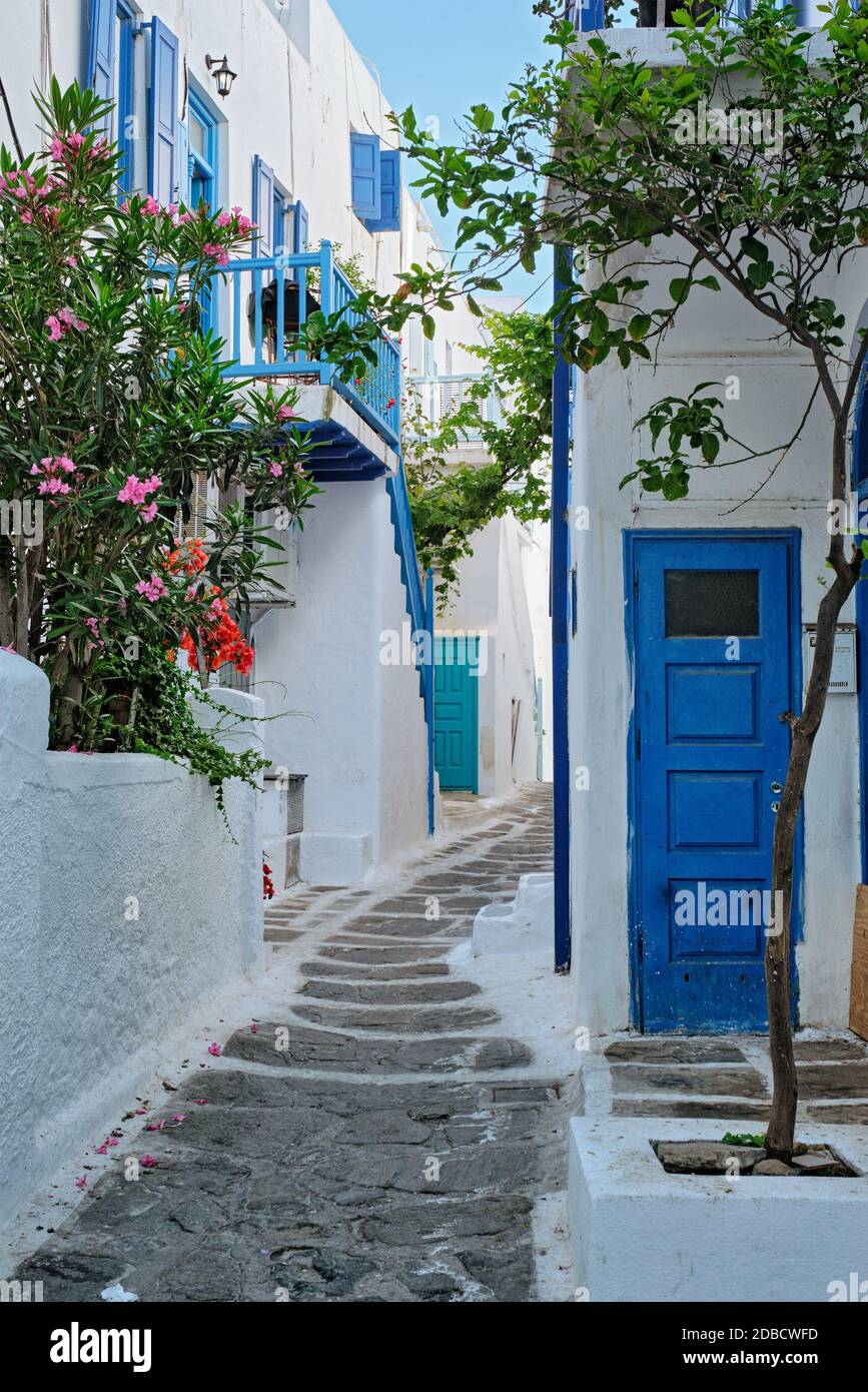 Picturesque scenic narrow streets with traditional whitewashed houses with blue doors windows of Mykonos Chora town in famous tourist attraction Mykon Stock Photo