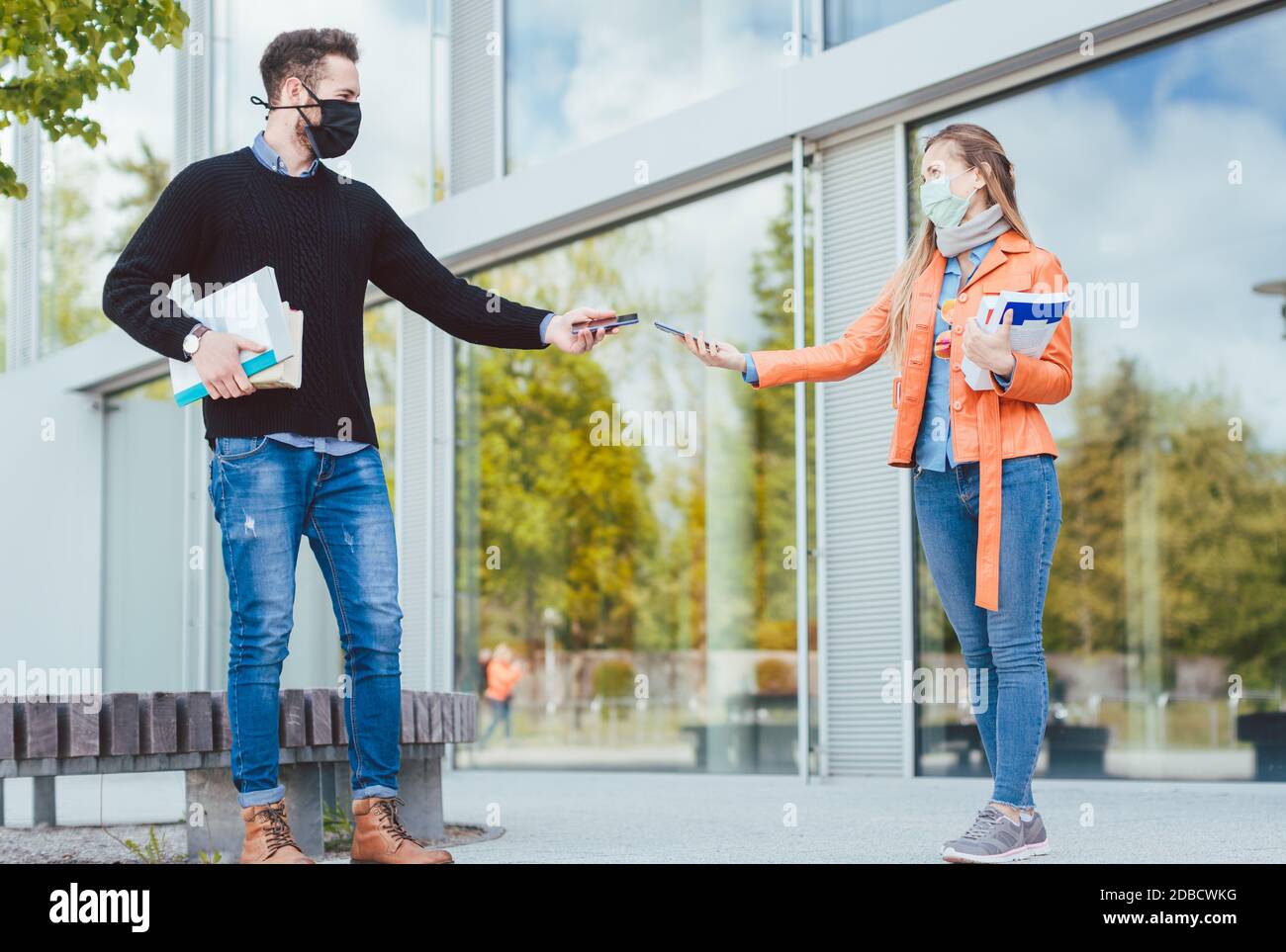 Two students during coronavirus crises with mobile phones and contract tracing app Stock Photo