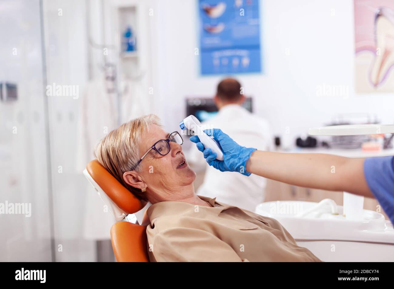 Dentist assistant holding digital body temperature indicator in front