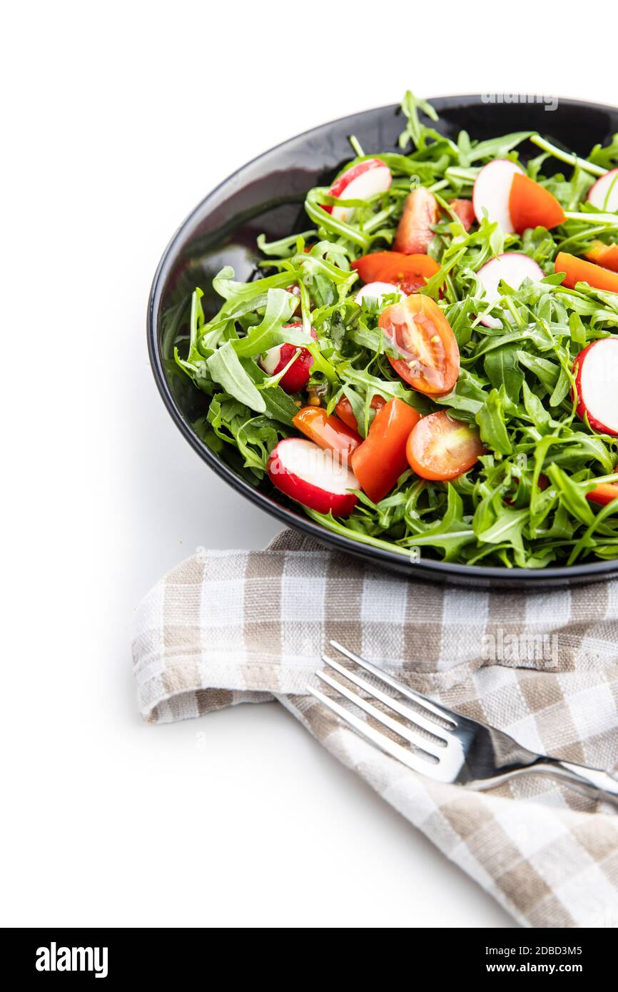 Fresh arugula salad with radishes, tomatoes and red peppers on plate. Stock Photo