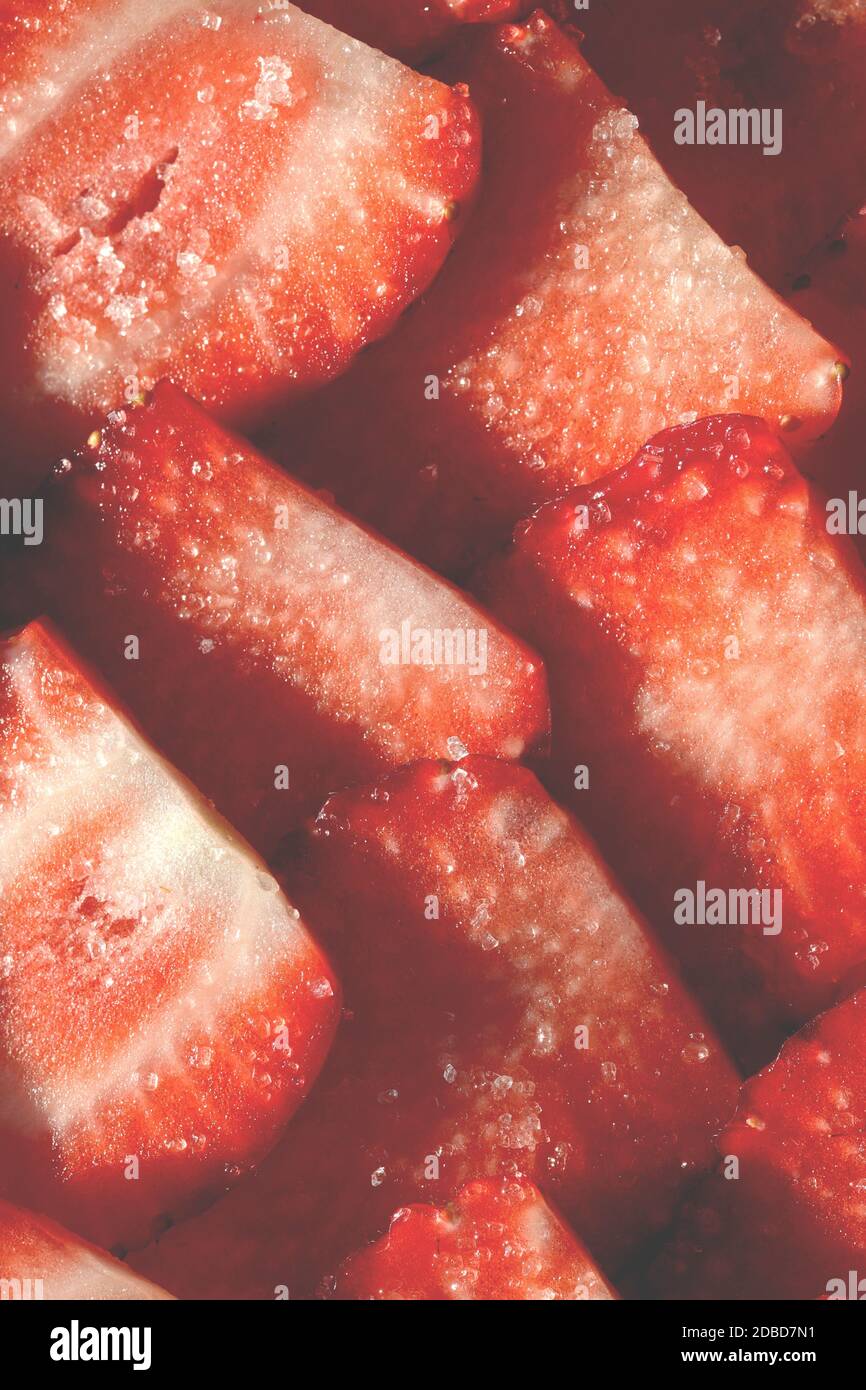 Strawberry slices in sugar filling background. Strawberry with sugar texture. Vitamin berry