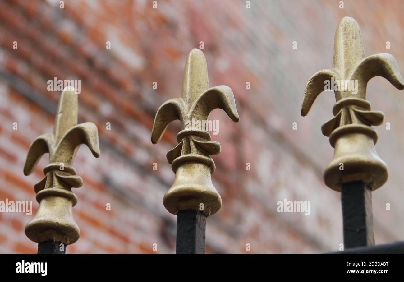 A closeup of an iron rod fence with gold Fleur De Lis ornaments on top. Taken in New Orleans. Stock Photo
