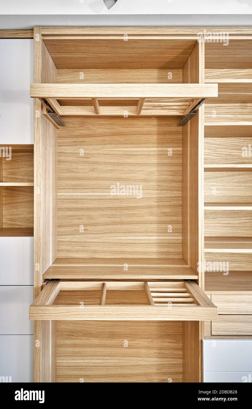 https://c8.alamy.com/comp/2DBDB28/internal-details-of-the-wooden-wardrobe-with-slide-out-rack-for-coathangers-oak-veneered-plywood-cabinets-with-light-gray-painted-cabinet-doors-deta-2DBDB28.jpg