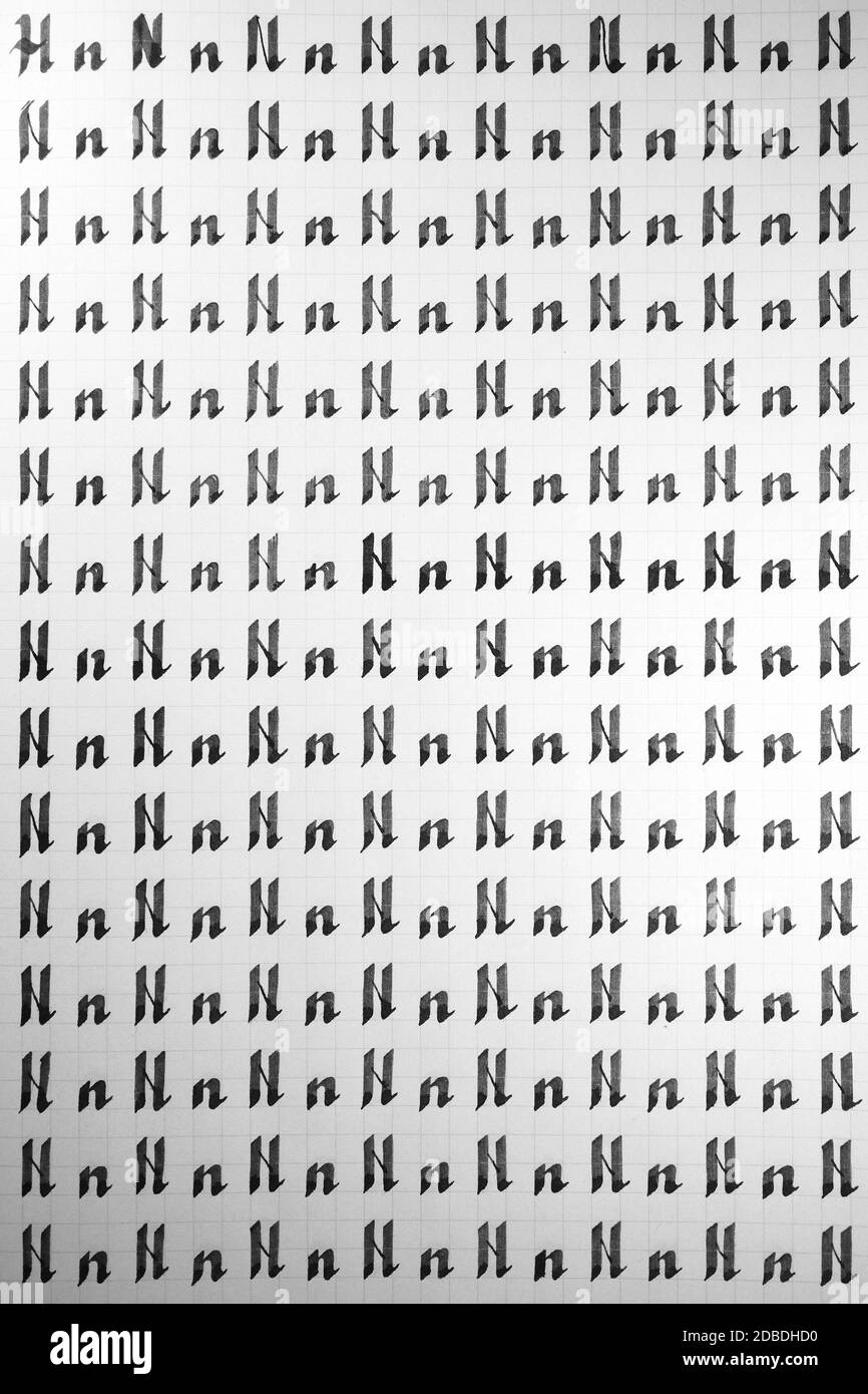 Calligraphy black and white letters N background. Lettering practice