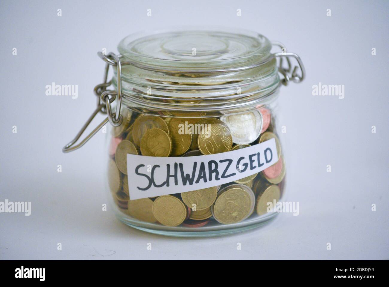 Jar with coins saying 'Schwarzgeld' (black money) Stock Photo