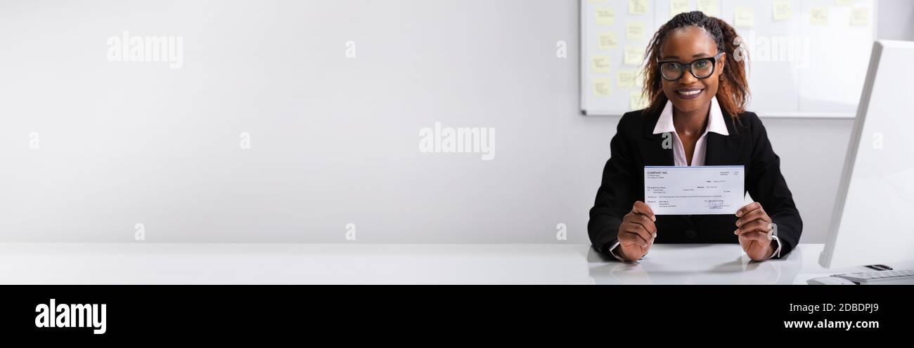 African American Boss Holding Paycheck Or Payroll Check Stock Photo