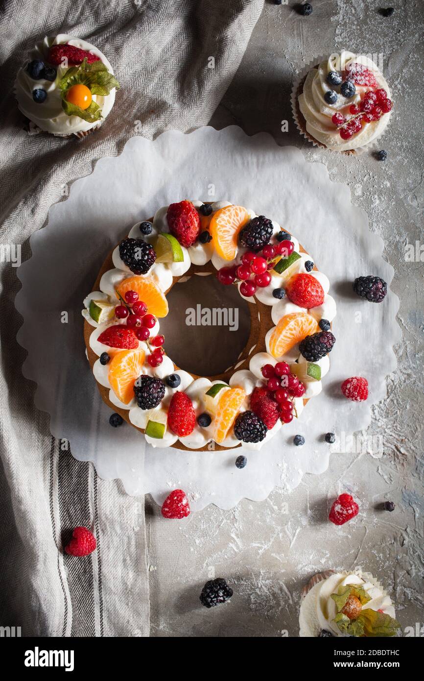 round pie with berries and cupcake on a gray background Stock Photo