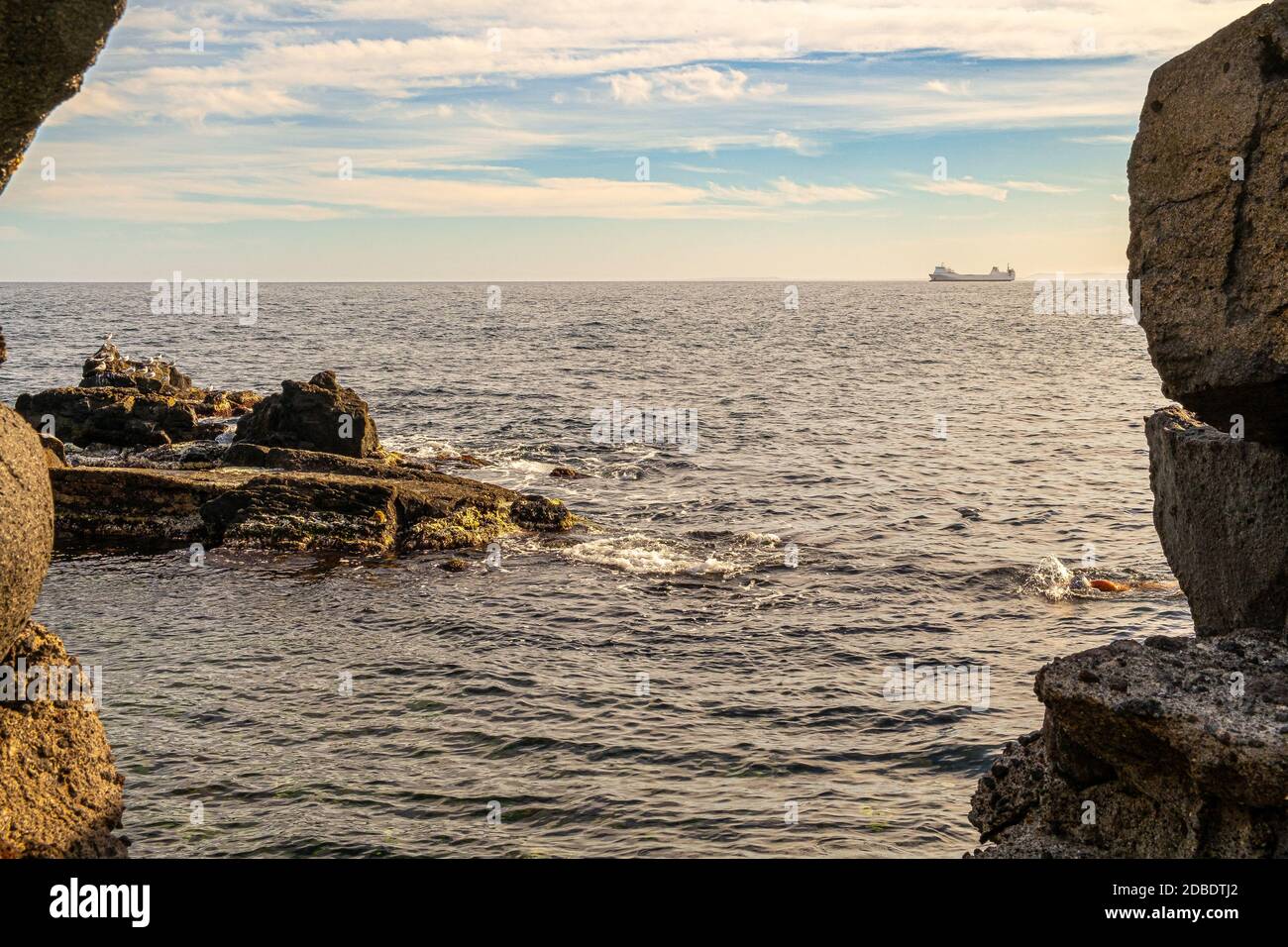 On the horizon there is a ship sailing Stock Photo - Alamy