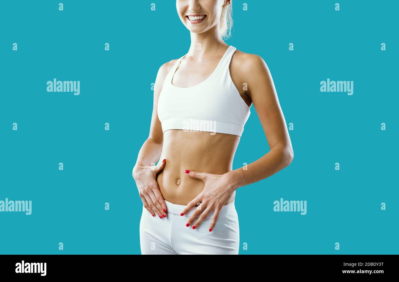 Beautiful fit woman posing and touching her belly: weight loss and wellbeing concept Stock Photo