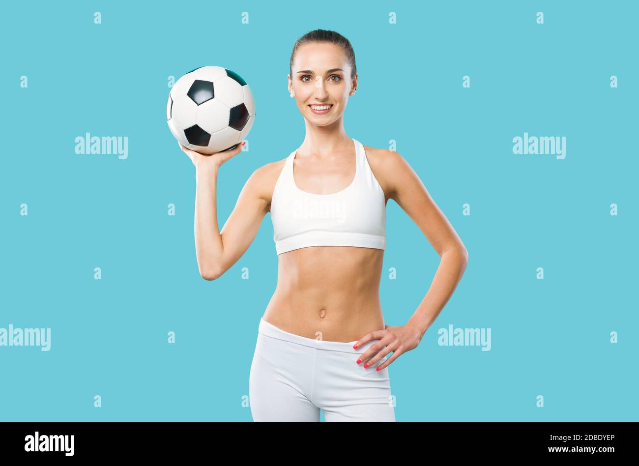 Happy female athlete holding a soccer ball and smiling, sports and challenge concept Stock Photo
