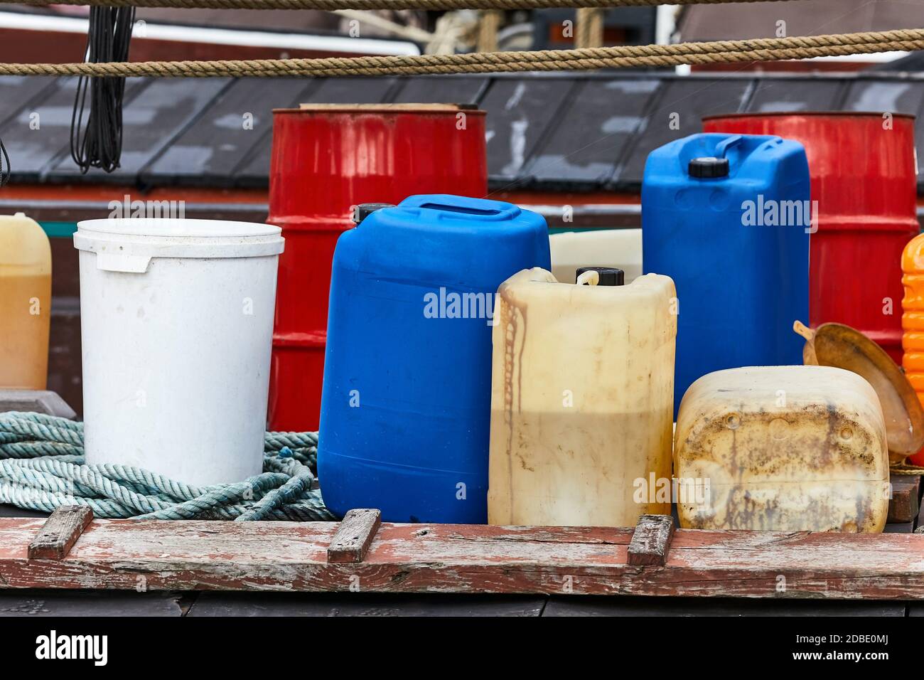 Various plastic cans with chemicals and fuel in a ship harbor Stock Photo