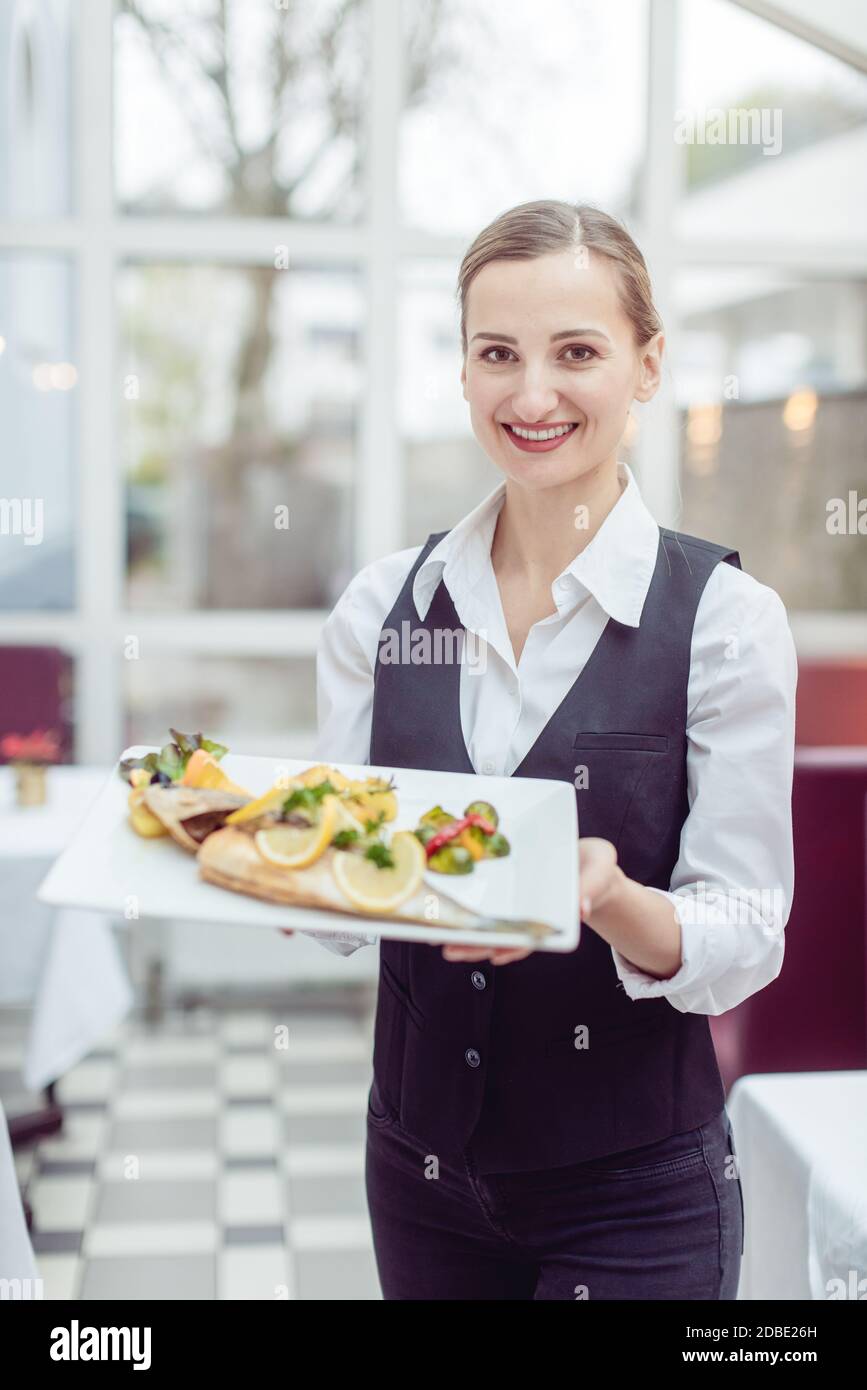Waitress In A Nice Restaurant Presenting A Tasty Dish To The Camera