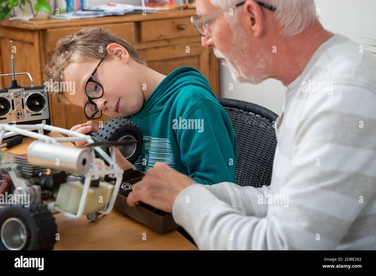 grandpa and son little boy repairing a model radio-controlled car Stock Photo