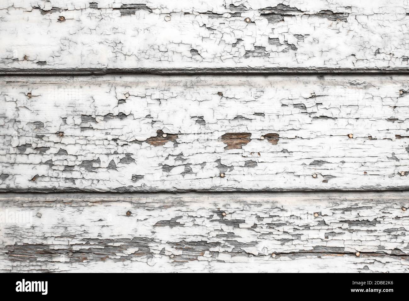 Old wooden painted white rustic fence, paint peeling background. Stock Photo
