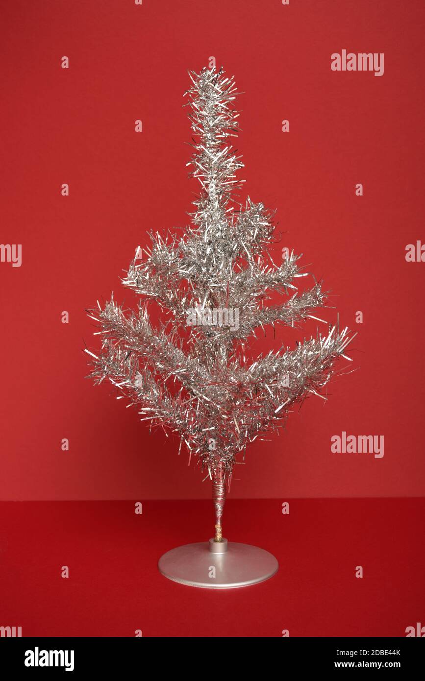 Silver tinsel Christmas tree on red background Stock Photo