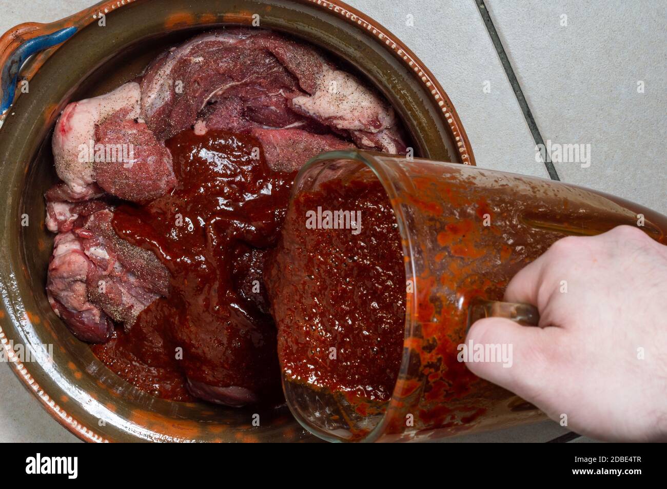 Cooking beef birria stew, Mexican food from Jalisco state. Raw seasoned  beef marinating in birria sauce Stock Photo - Alamy