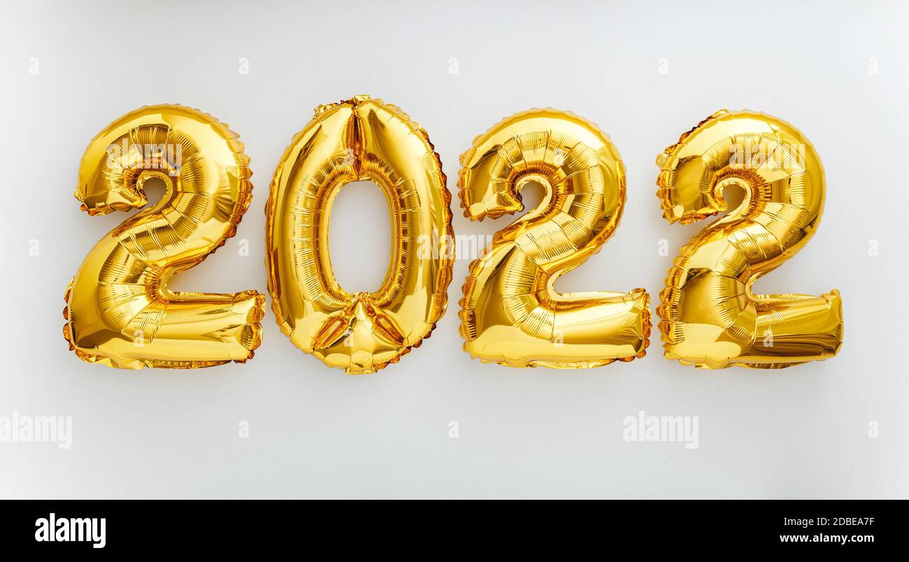 2022 balloon text on white background. Happy New year eve invitation with Christmas gold foil balloons 2022. Flat lay long web banner Stock Photo