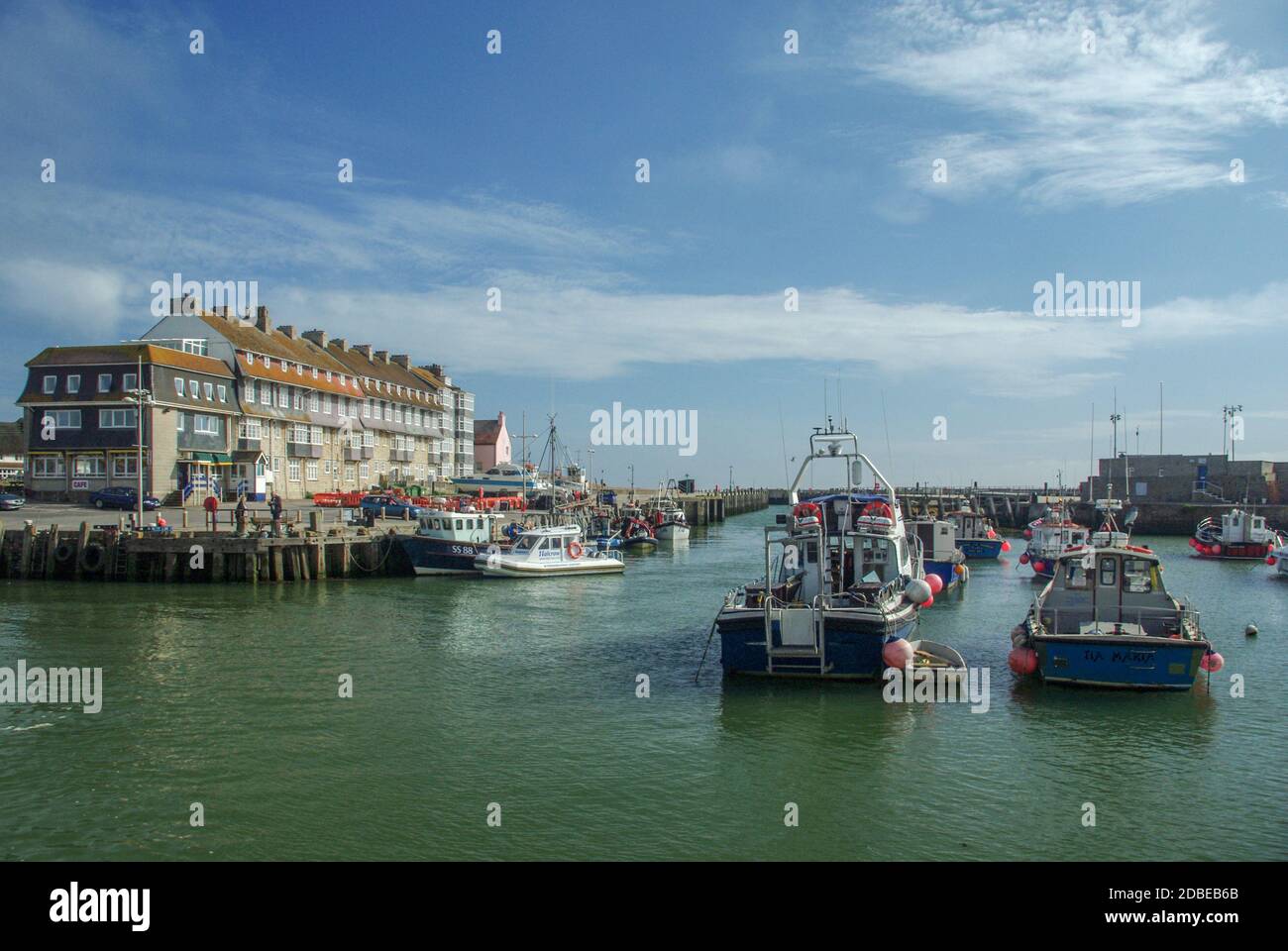Boats and fishing boats in the harbour at West Bay, a popular West Country holiday resort; Bridport, Dorset, UK Stock Photo
