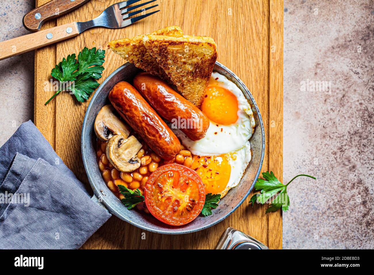 English breakfast with sausages, beans, fried eggs, toast, mushrooms