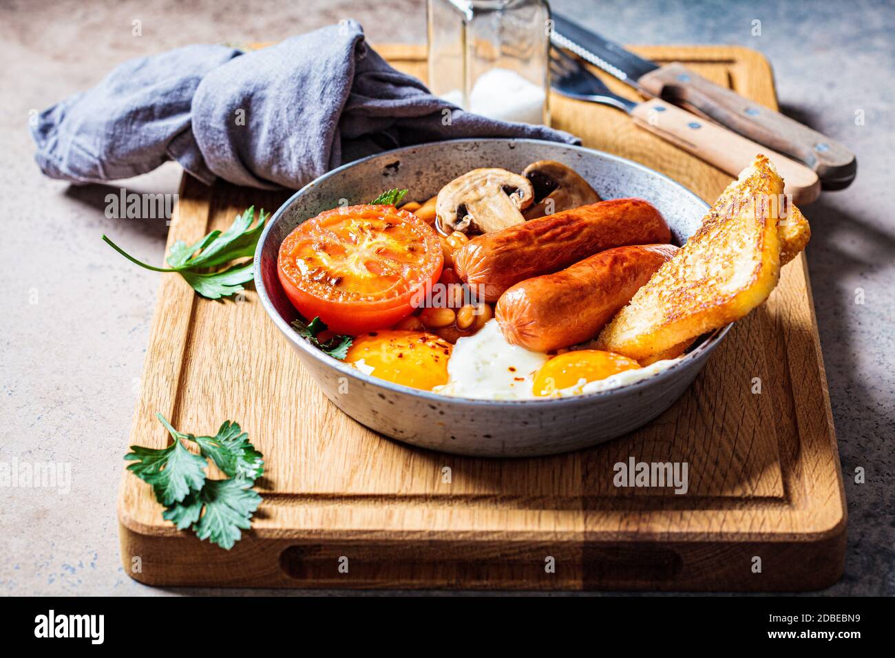 English breakfast with sausages, beans, fried eggs, toast, mushrooms