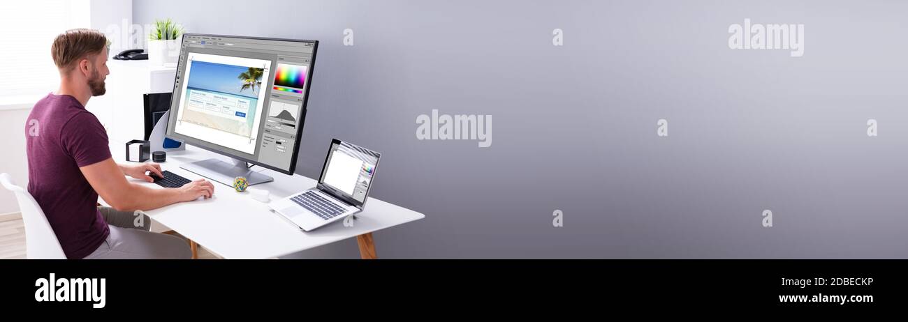 Designer Editing Photos On Multiple Computer Screens Stock Photo