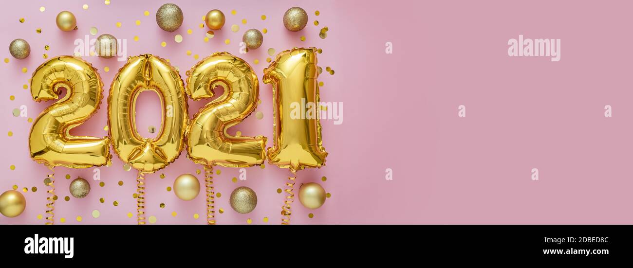 2021 air balloon gold text on pink background with golden confetti, Christmas gold balls, festive decor. Happy New year eve invitation with Christmas Stock Photo