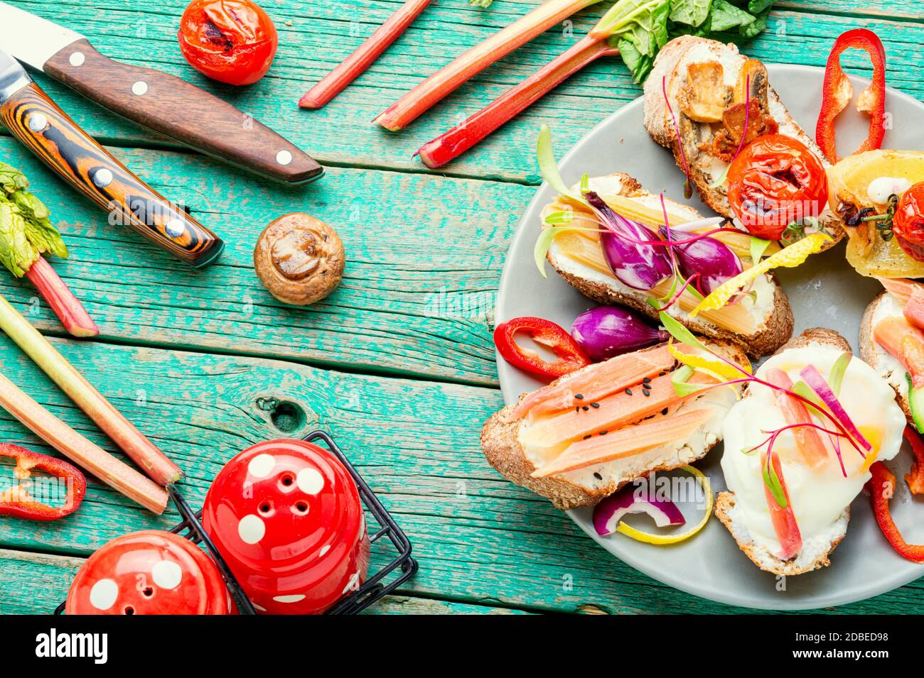 Tasty italian bruschetta with vegetables and ingredients on the kitchen table Stock Photo
