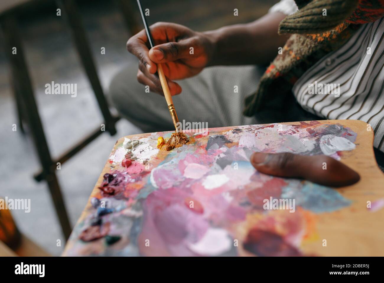 Male painter holds brush and colorful paints on palette, art studio ...
