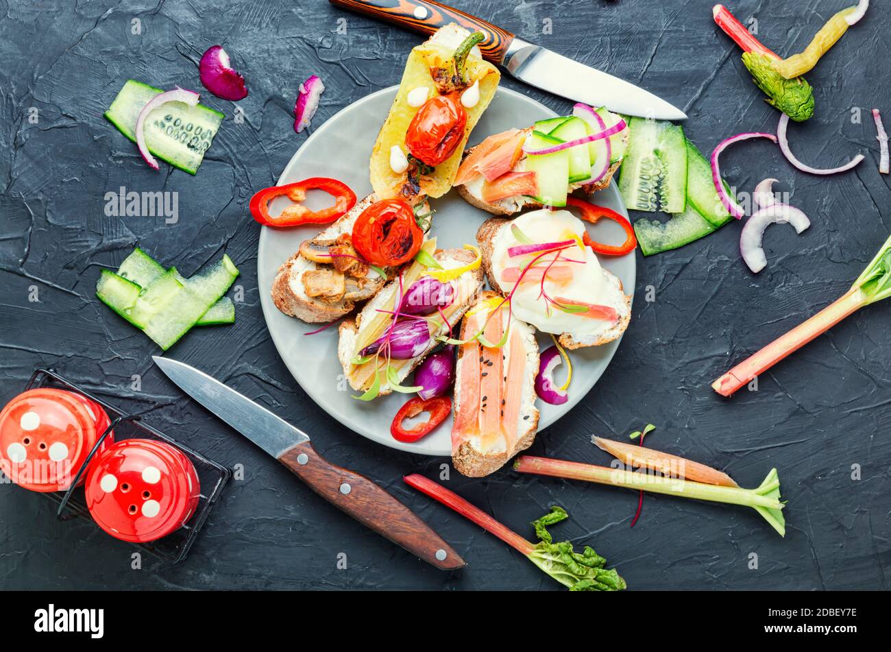 Tasty italian bruschetta with vegetables and ingredients on the kitchen table Stock Photo
