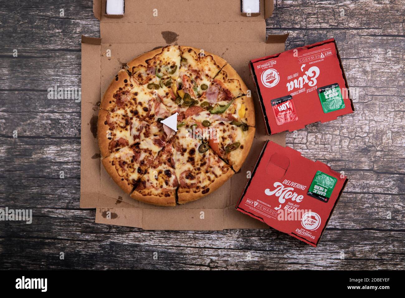 Still life photograph of pizza in Pizza Hut box with side dishes Stock