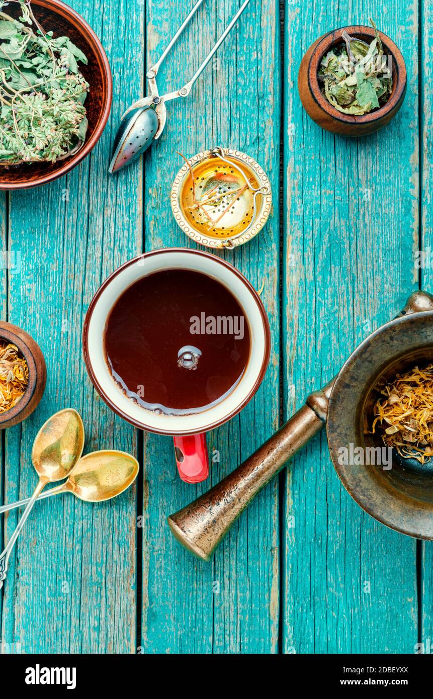 Cup with useful tea from medicinal herbs on a wooden background.Various herbal tea ingredients Stock Photo