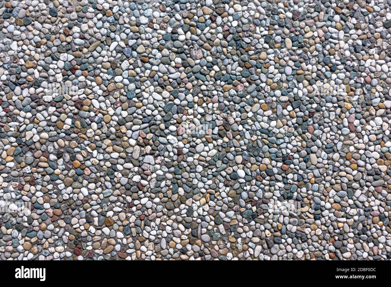 Exposed aggregate concrete with different colored pebbles Stock Photo