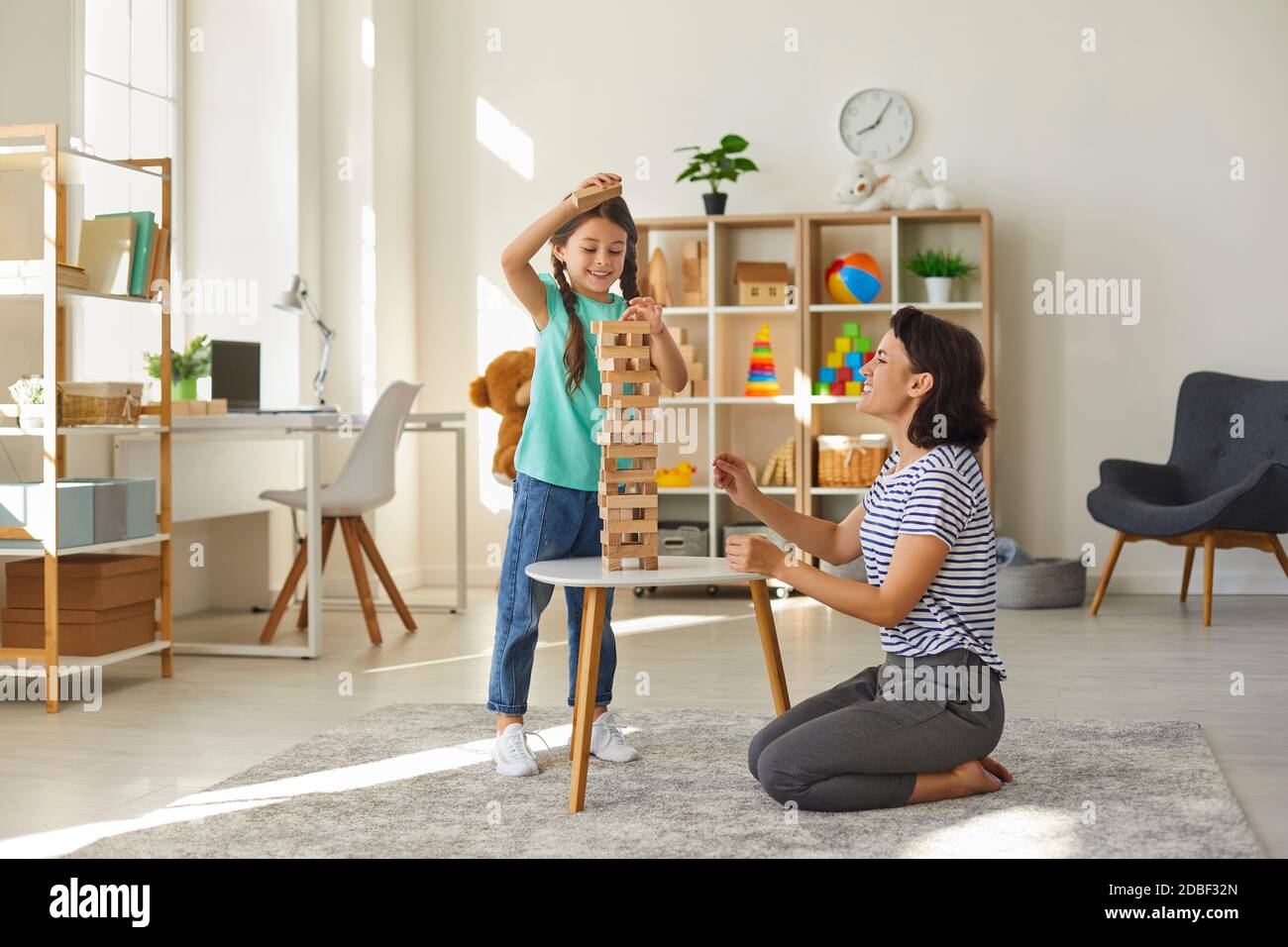 Mother and daughter play board games at home. Happy family Stock Photo