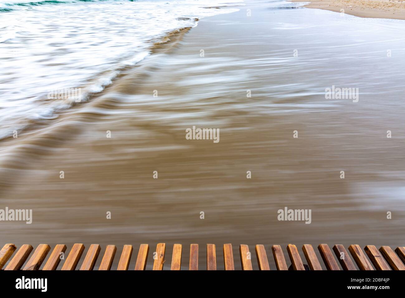 Sea surf rolling ashore after sunset, blurry with a long exposure Stock Photo