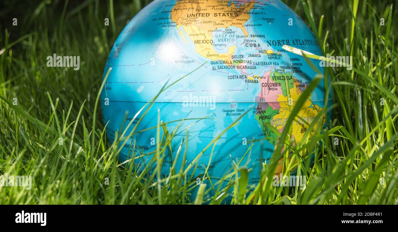 The globe model of the Earth in green grass showing ECO concept ...