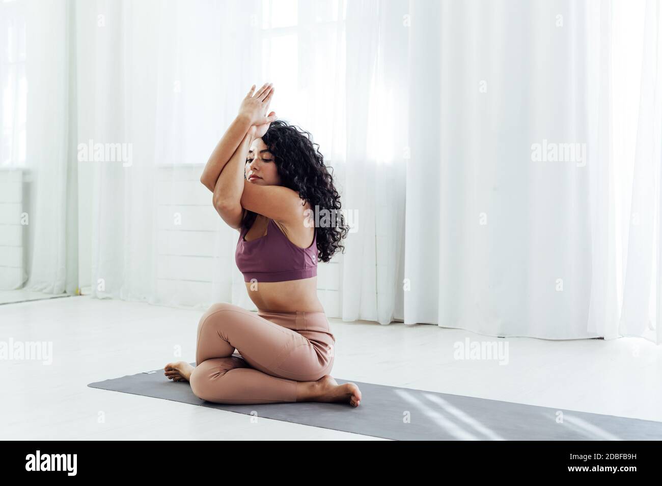 Oriental woman engaged in yoga class asana gymnastics fitness flexibility Stock Photo